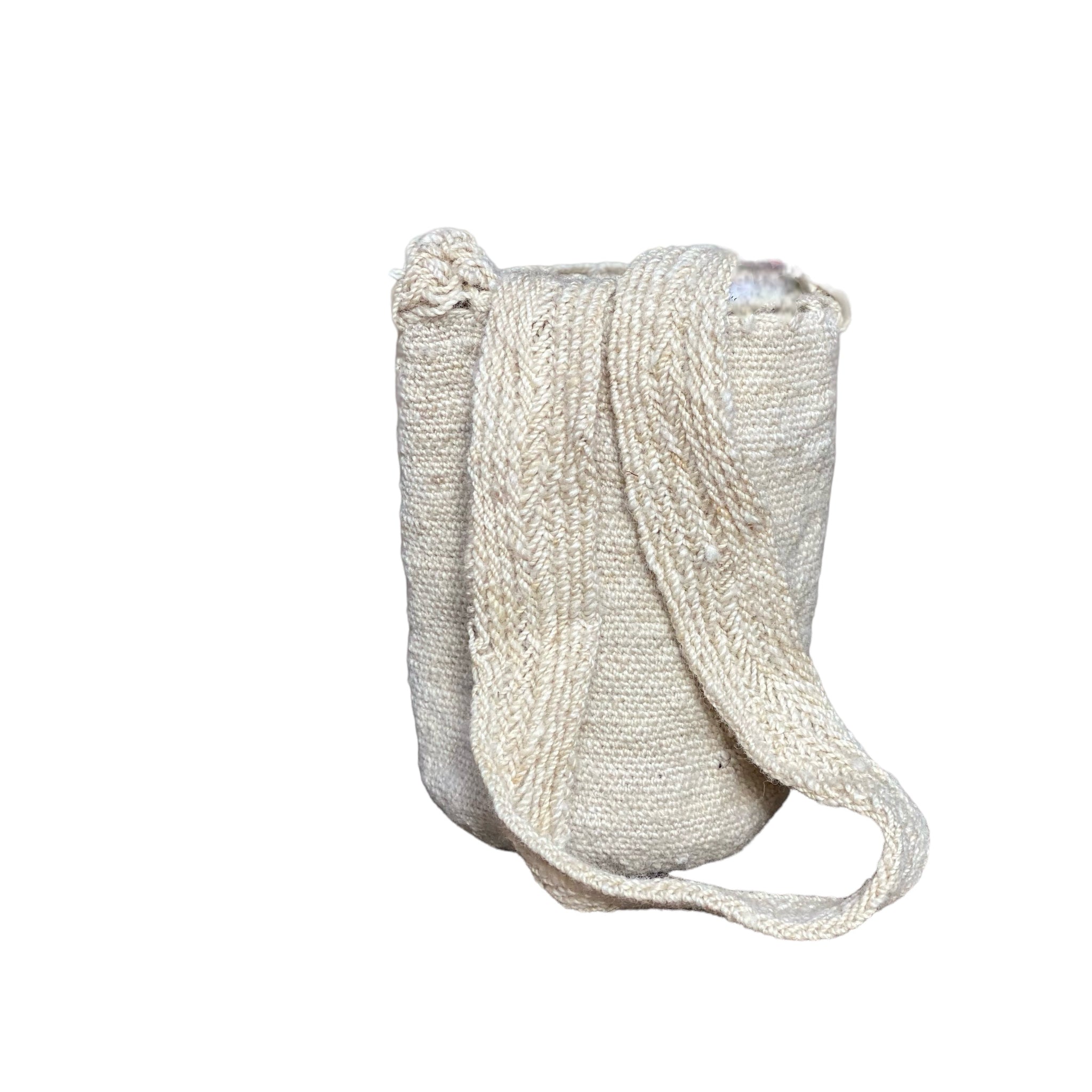 Borsa a secchiello di colore neutro, bianco sporco. focus sulla tracolla che ne denota l'artigianalità. in pura lana intrecciata a mano dalle donne indigene delle Ande colombiane. Bianco, panna, neutro