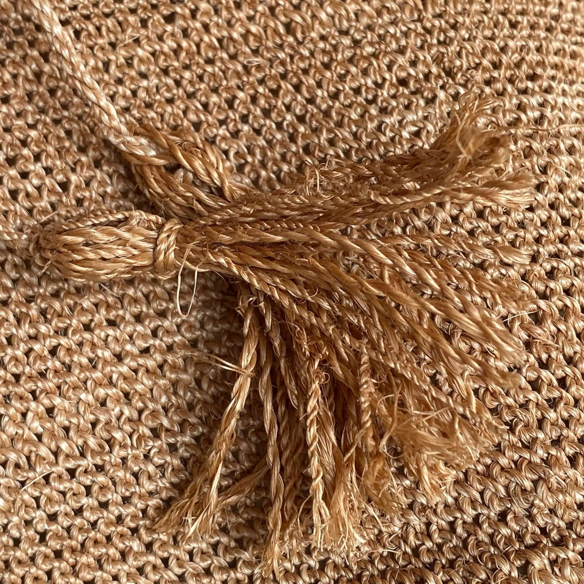 Dettaglio della trama rustica e delle nappine della FIBI Bag Madera