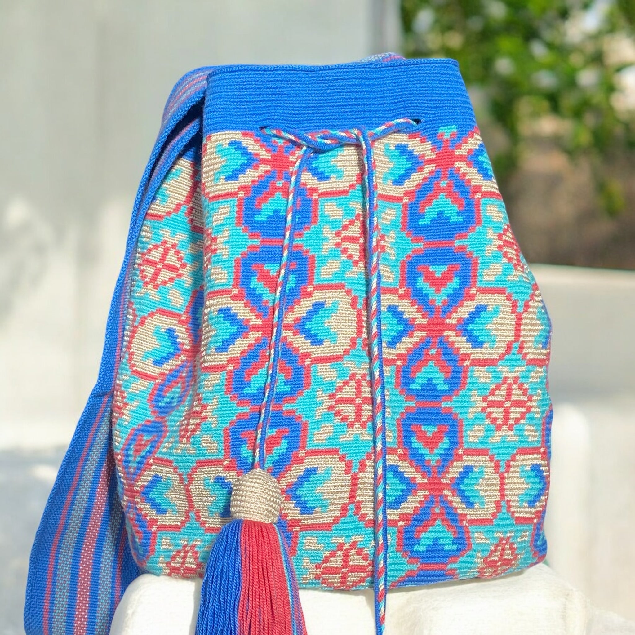 Ipanema Mochila Wayuu - Borsa artigianale azzurra con disegni floreali e geometrici nei toni rosa e champagne fatta a mano in Colombia
