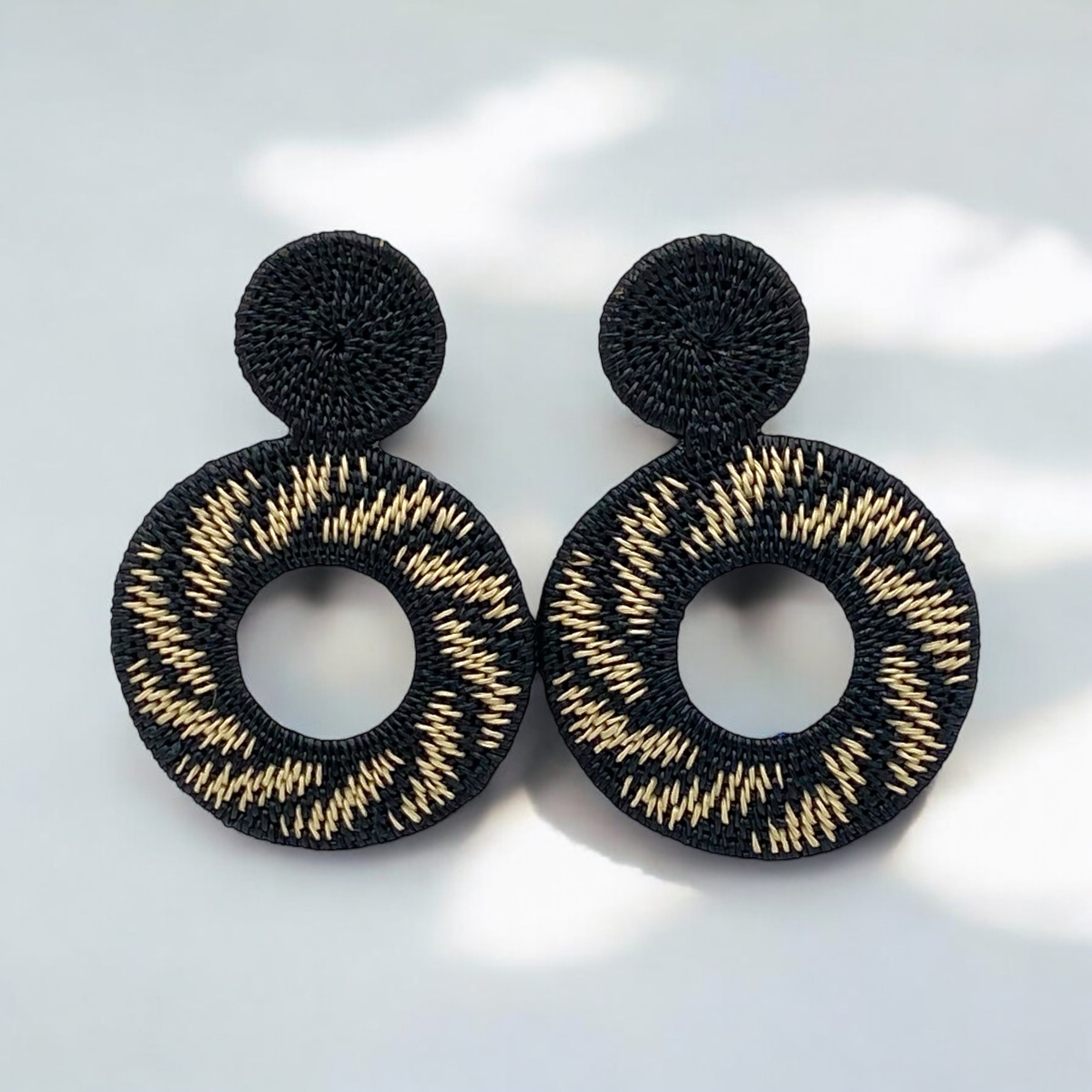 Orecchini pendenti artigianali in fibra di palma Werregue, intrecciati a mano dalle comunità indigene colombiane. Cerchi neri e bianchi