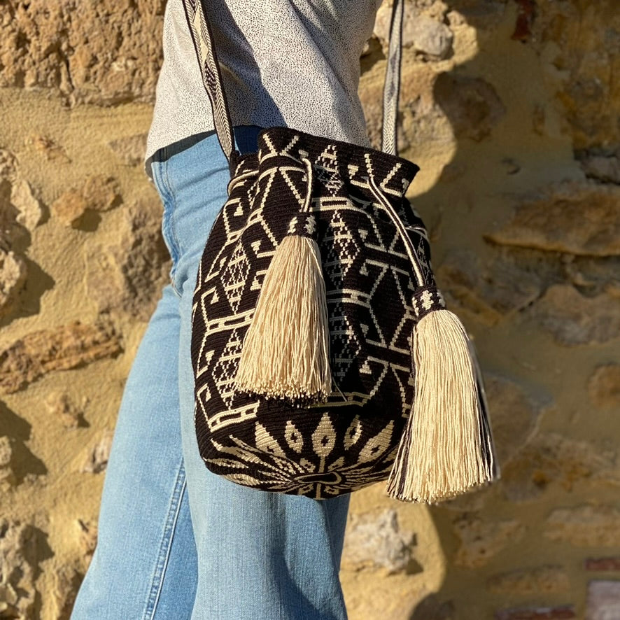 Borsa Wayuu grande Katuma indossata a tracolla, intrecciata a mano con motivi sabbia su base nera