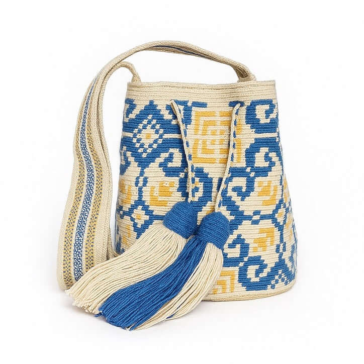 Mochila Wayuu Solmar artigianale piccola in toni sabbia, blu e giallo ocra con nappine e tracolla intrecciata – Volver Bags
