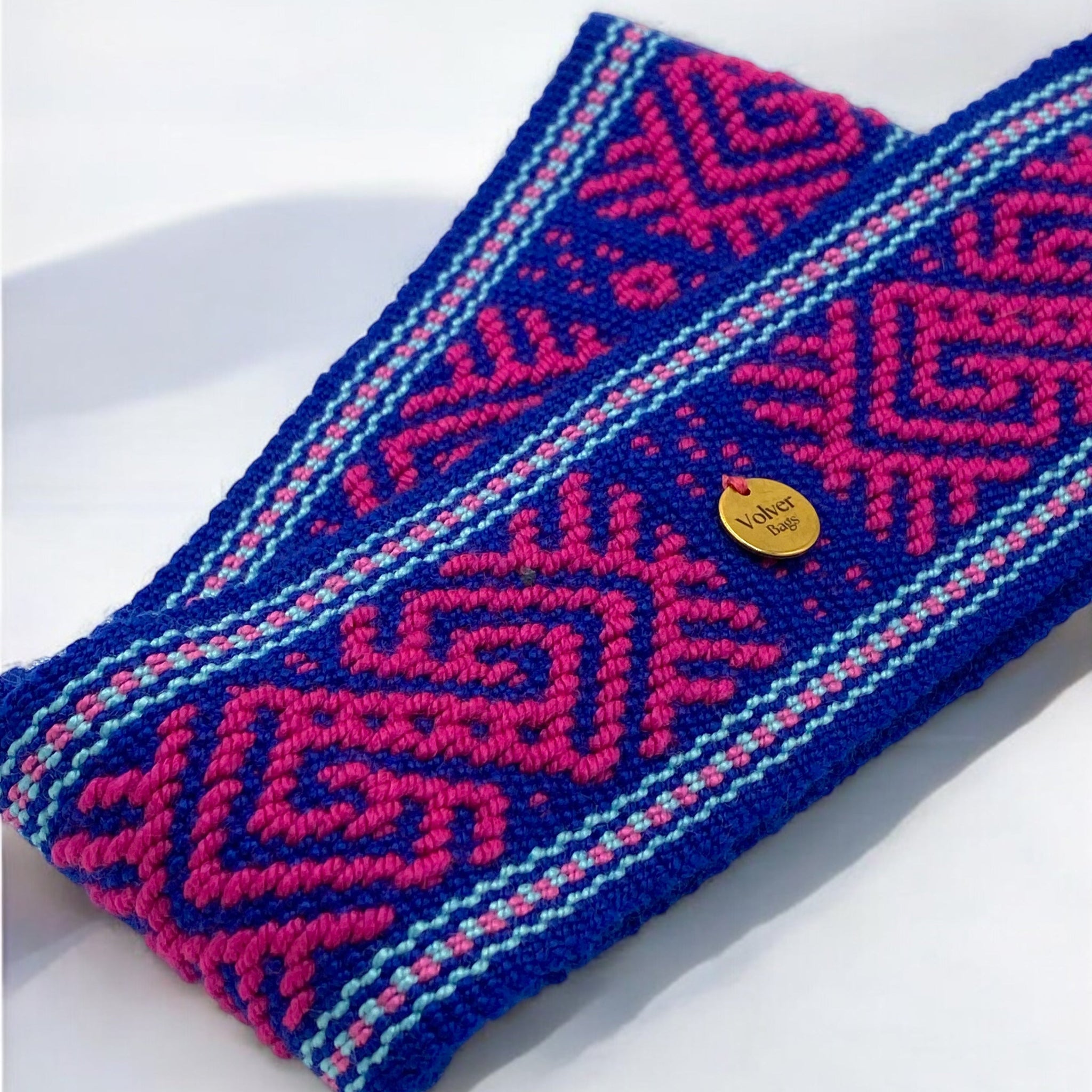 focus sulla trama della cintura artigianale tessuta a mano in cotone, colori blu elettrico, rosa fucsia e azzurro, realizzata da artigiane colombiane