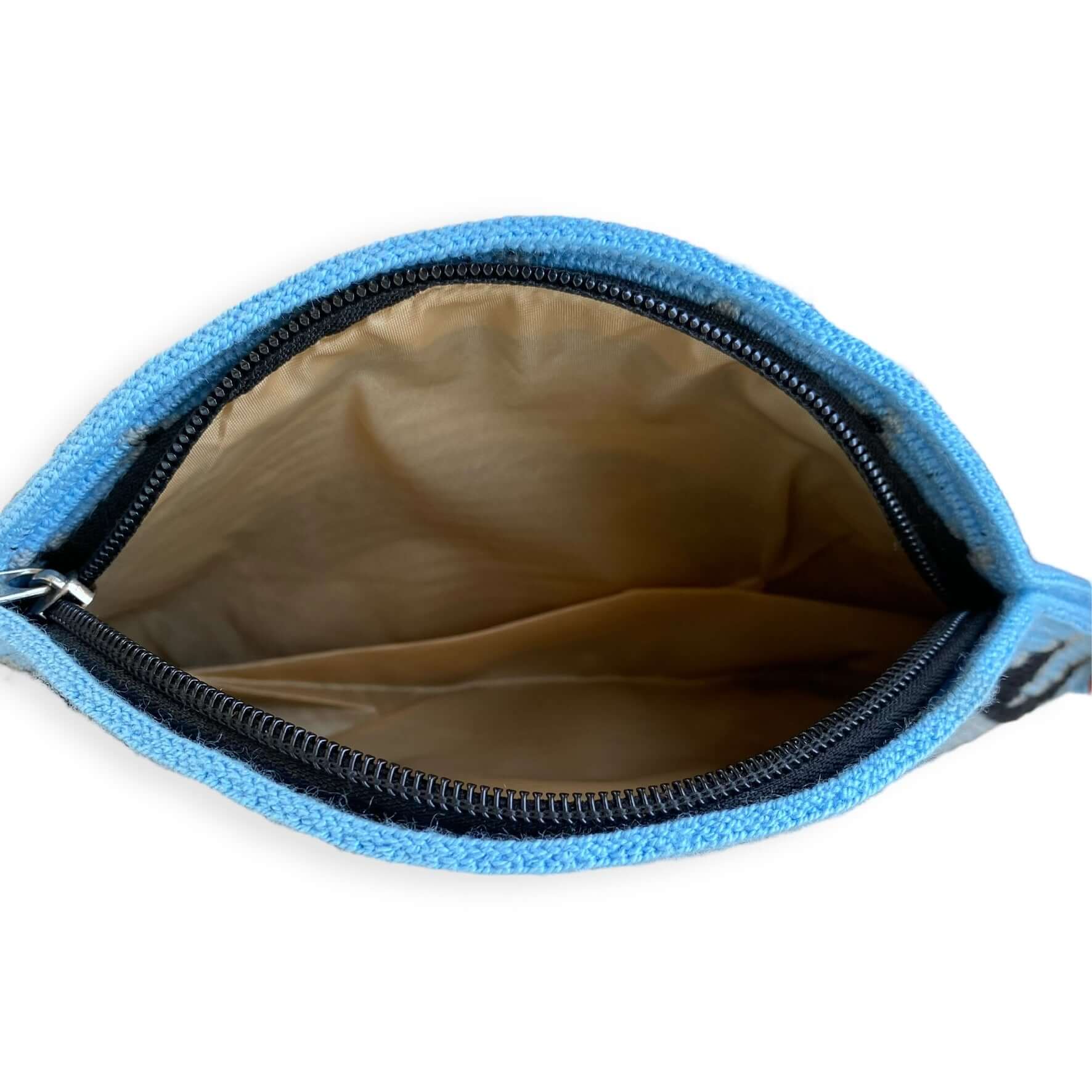 dettaglio zip clutch Wayuu a uncinetto azzurro polvere, grigio e nero con dettaglio nappina – borsa etica Volver Bags