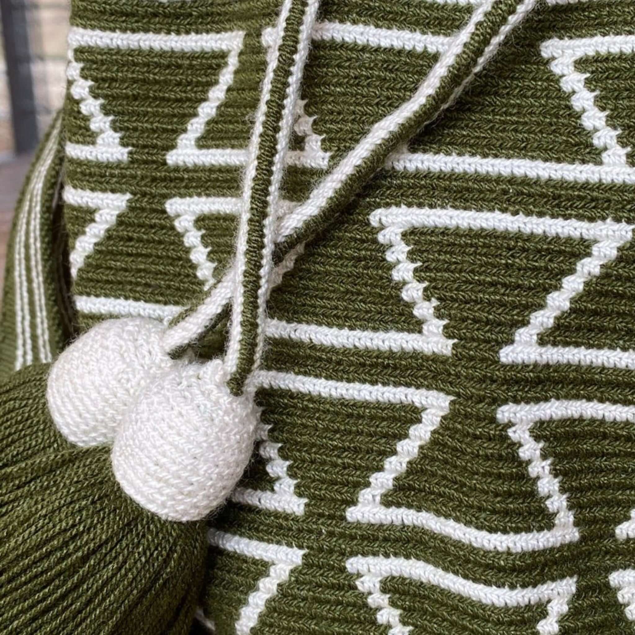 Dettaglio ravvicinato della Mochila Torres: nappine finemente lavorate e texture artigianale, esempio della qualità unica delle borse Wayuu