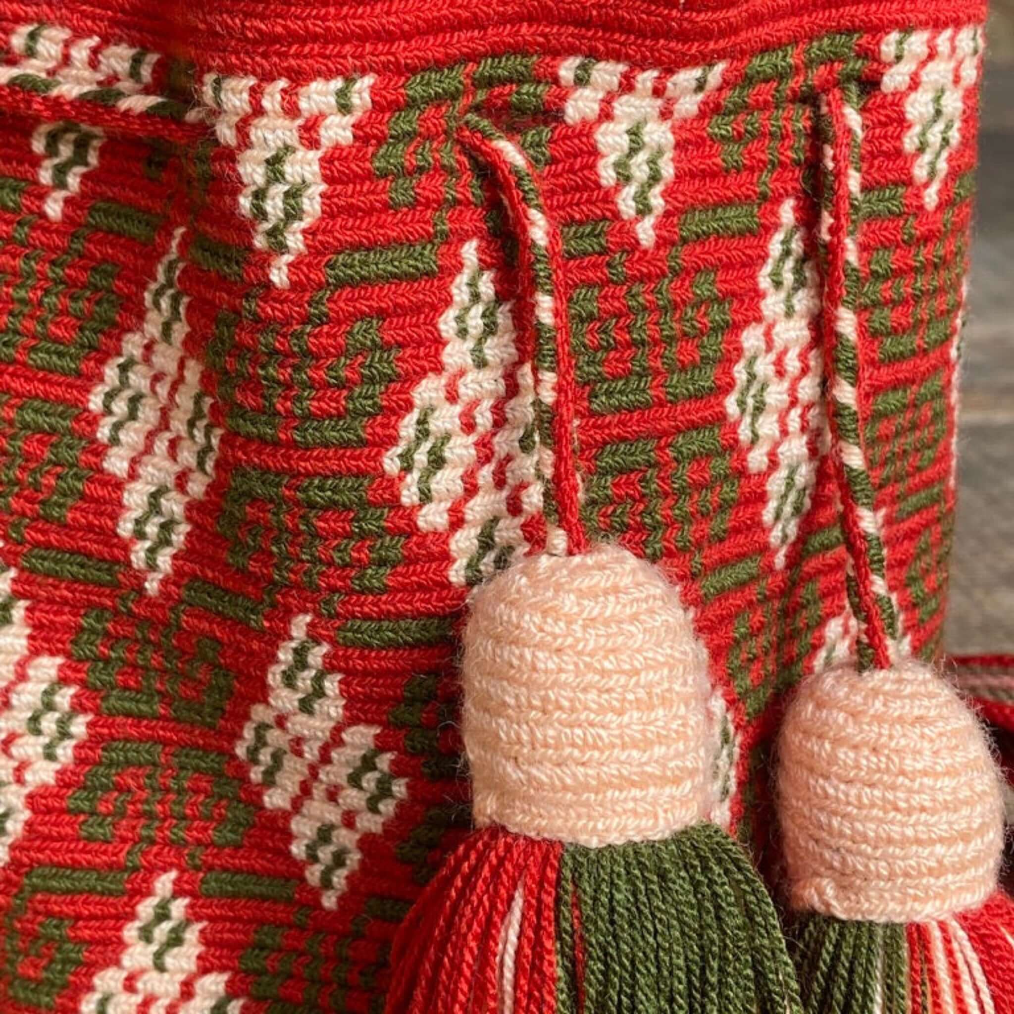 Dettaglio ravvicinato di una borsa artigianale Wayuu: texture all'uncinetto, motivi etnici e nappine che riflettono l'autenticità della tradizione colombiana