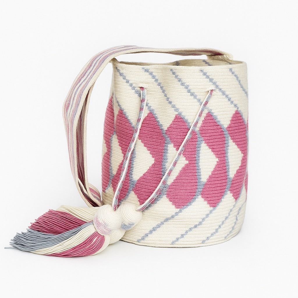 Borsa Wayuu intrecciata a filo singolo con motivi fucsia e azzurri, nappine rifinite e tracolla tessuta a mano – simbolo dell’artigianato autentico colombiano