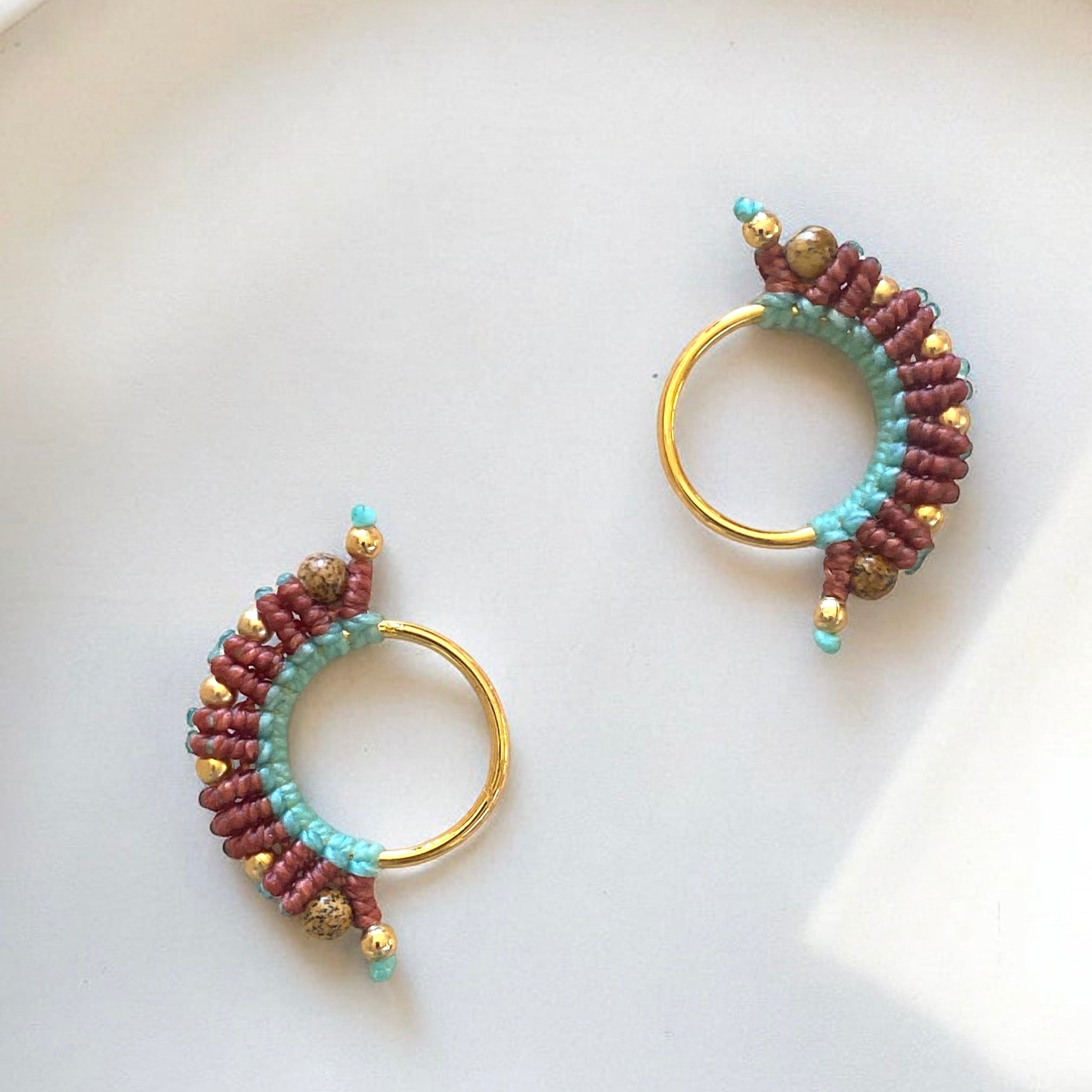 Gioiello colombiano in macramè con fili azzurri e uva, dettagli in bronzo placcato oro