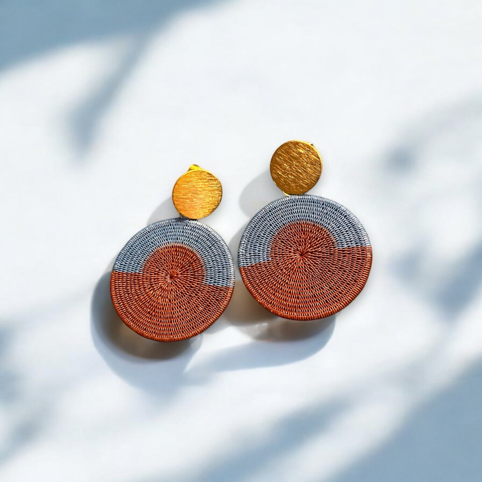 Orecchini pendenti artigianali in fibra di palma Werregue, intrecciati a mano dalle comunità indigene colombiane. Marrone e grigio. Punto luce oro