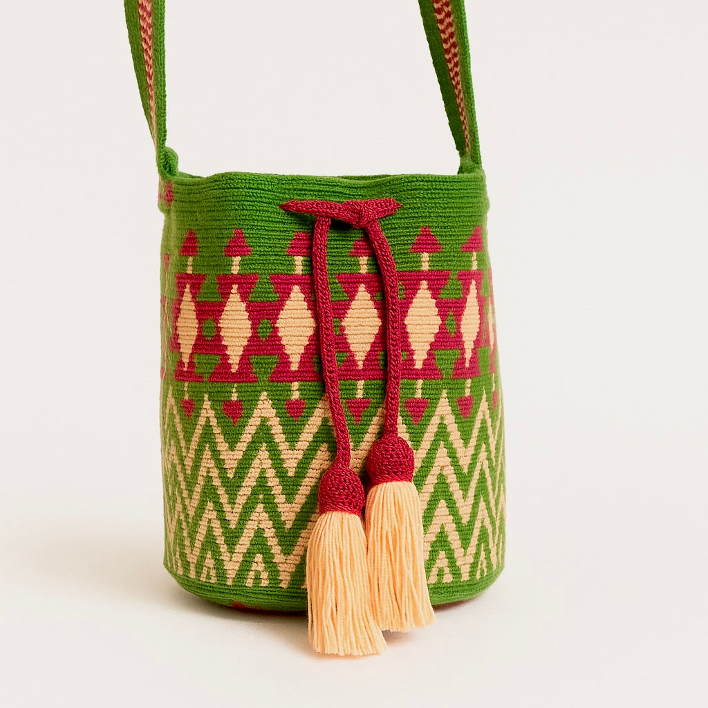 Mochila Wayuu piccola dai toni vivaci del verde giungla, rosa intenso e tenue, intrecciata a mano in Colombia