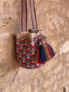 Borsa Wayuu beige, rossa e azzurra, realizzata a mano in Colombia. Cappine e tracolla realizzata al telaio. Il fascino unico dell'artigianato colombiano.