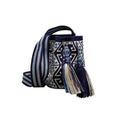 Borsa Wayuu blu e avorio fatta a mano, con motivi geometrici e nappine, fotografata su sfondo bianco per evidenziarne forma e texture.
