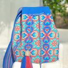 Ipanema Mochila Wayuu - Borsa artigianale azzurra con disegni floreali e geometrici nei toni rosa e champagne fatta a mano in Colombia