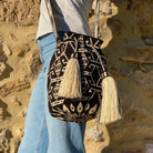Borsa Wayuu grande Katuma indossata a tracolla, intrecciata a mano con motivi sabbia su base nera



