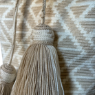 dettaglio nappe e trama della borsa sechiello artiginale colombiana Miel nei toni beige e bianco
