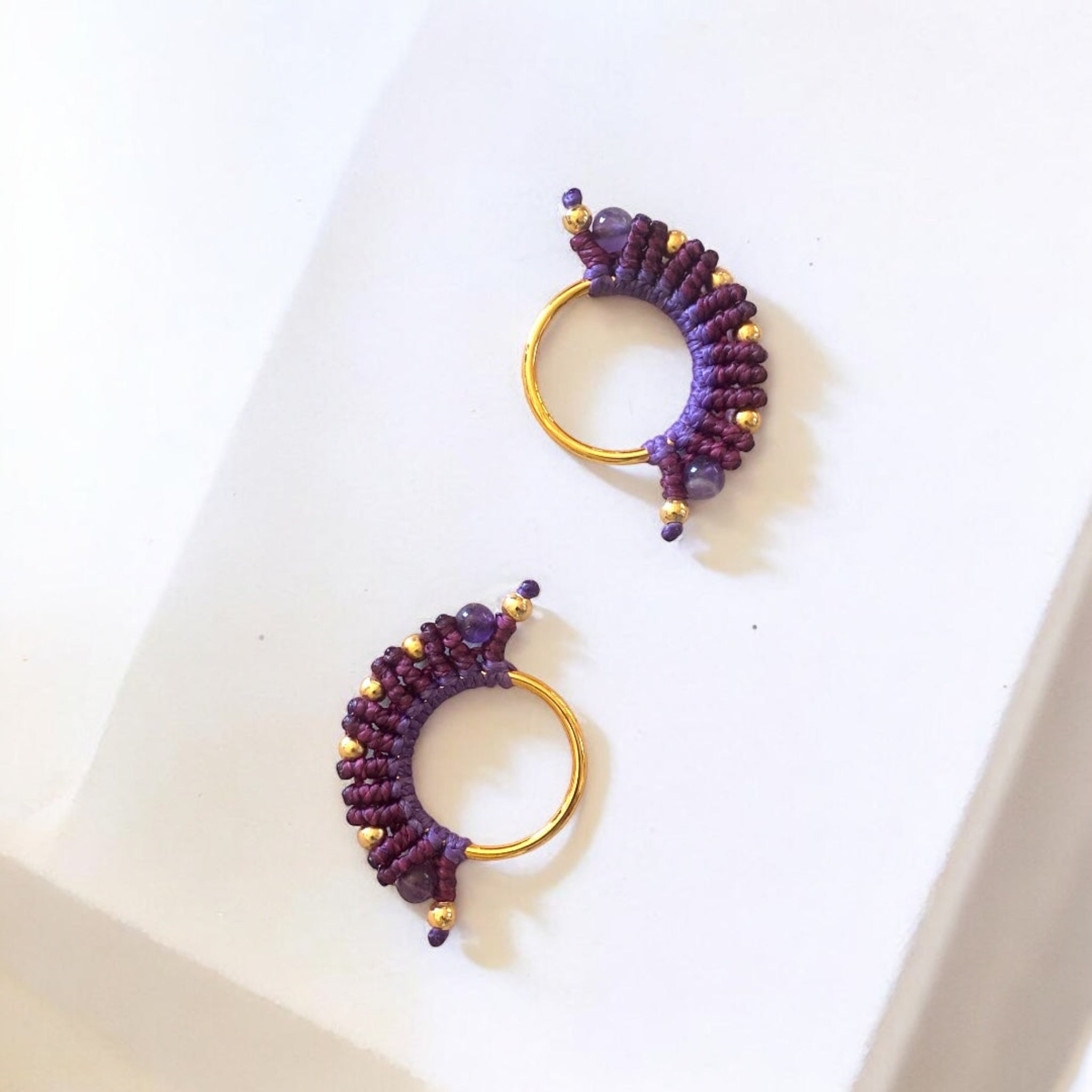 Gioiello colombiano viola sfumato, intrecciato a mano in macramè con dettagli oro 24k