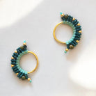 Orecchino macramè con fili di cotone in verde menta chiaro e un verde più intenso, annodato artigianalmente e completato da dettagli dorati.”