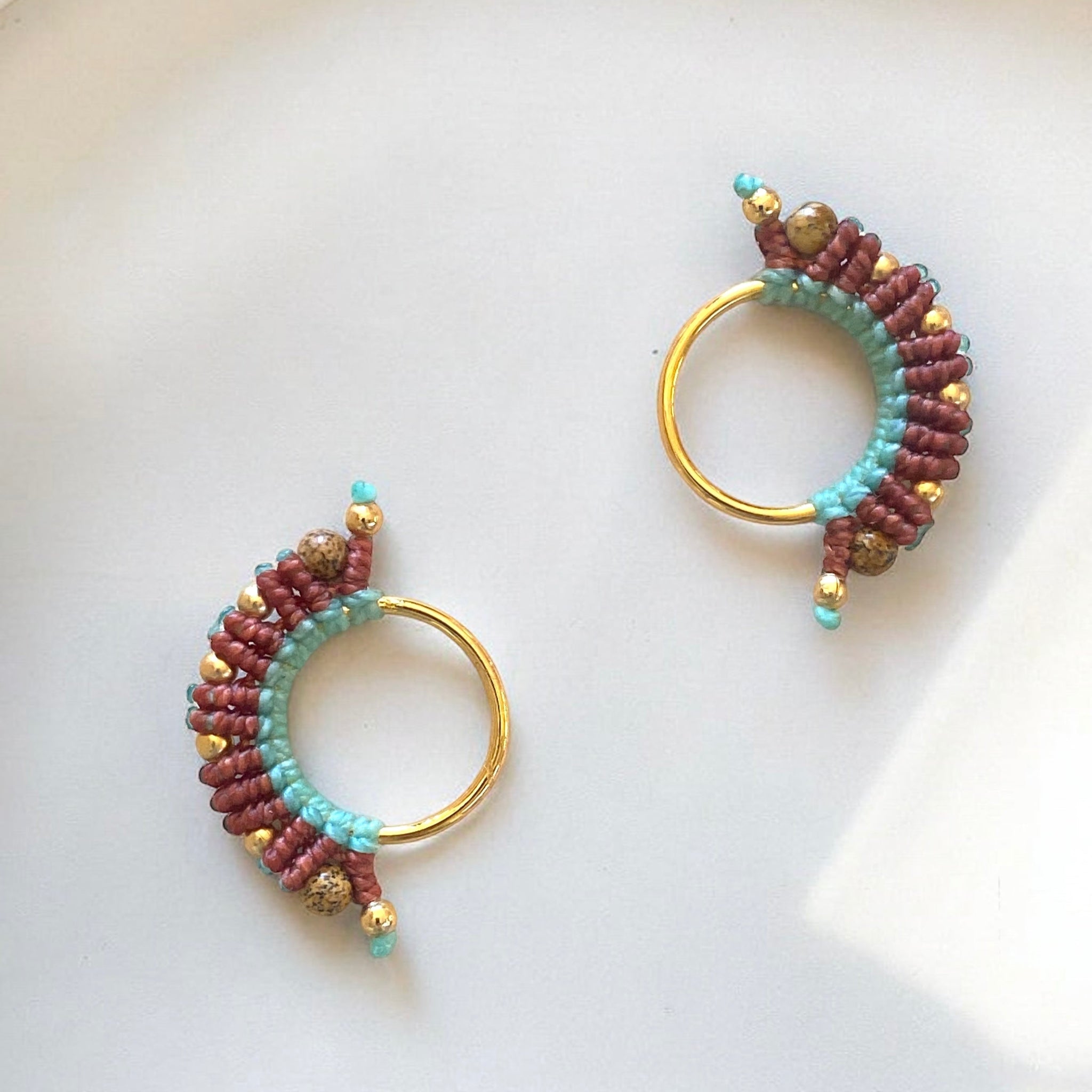 orecchino artigianale colombiano in fili di cotone rosa e terra cotta, base in bronzo con bagno d’oro