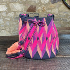 Mochila Wayuu media, lavorazione a uncinetto con rombi e geometria nei toni grigi, arancio e fucsia – artigianato autentico colombiano
